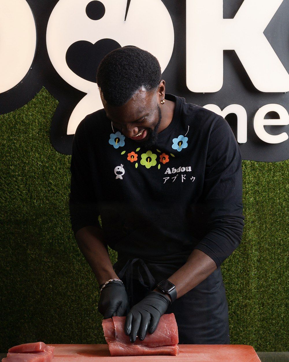 Abdou prépare le thon derrière le comptoir de PokeMe, à Lausanne